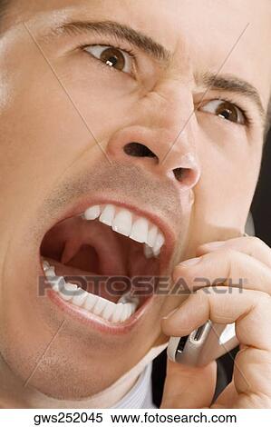 Close-up of a businessman shouting on a mobile phone View Large Photo Image Stock Photography - Close-up of a businessman shouting on a mobile phone. Fotosearch