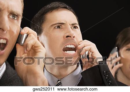 Stock Image - Close-up of business executives shouting on mobile phones. Fotosearch