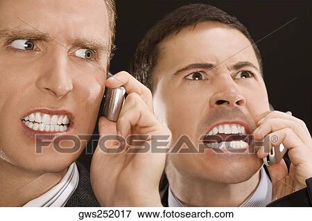 Stock Photo - Close-up of two business executives shouting on mobile phones. Fotosearch