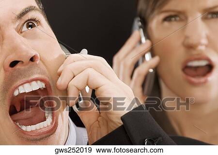 Close-up of two business executives shouting on mobile phones View Large Photo Image Stock Photo - Close-up of two business executives shouting on mobile phones. Fotosearch