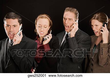 Stock Image - Four business executives talking on mobile phones. Fotosearch