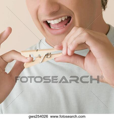 Close-up of a young man pinching his finger with a clothespin View Large Photo Image Stock Photograph - Close-up of a young man pinching his finger with a clothespin. Fotosearch