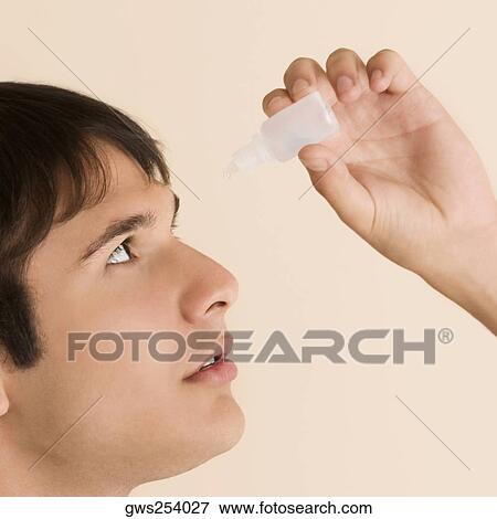 Close-up of a young man putting eye drops in his eyes View Large Photo Image Stock Photo - Close-up of a young man putting eye drops in his eyes. Fotosearch