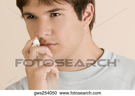 Close-up of a young man smelling a perfume View Large Photo Image Stock Image - Close-up of a young man smelling a perfume. Fotosearch