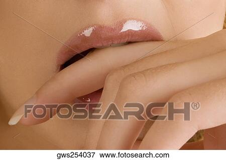 Close-up of a young woman biting her finger View Large Photo Image Stock Photo - Close-up of a young woman biting her finger. Fotosearch