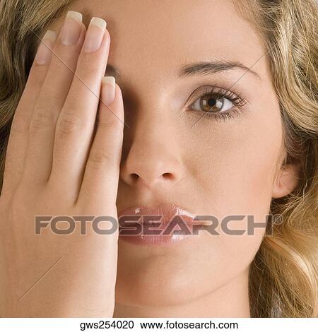 Close-up of a young woman covering her one eye View Large Photo Image Stock Image - Close-up of a young woman covering her one eye. Fotosearch