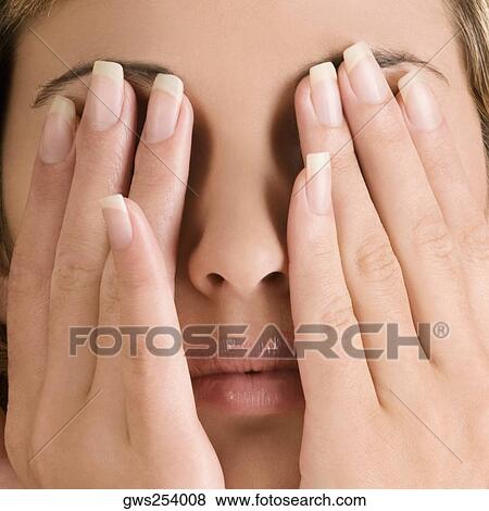 Close-up of a young woman covering her eyes with her hands View Large Photo Image Stock Photo - Close-up of a young woman covering her eyes with her hands. Fotosearch