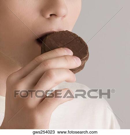 Close-up of a young woman eating a cookie View Large Photo Image Stock Image - Close-up of a young woman eating a cookie. Fotosearch