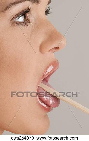 Close-up of a young woman using a tongue depressor to examine her tongue View Large Photo Image Stock Image - Close-up of a young woman using a tongue depressor to examine her tongue. Fotosearch