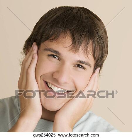 Portrait of a young man with his head in his hands and smiling View Large Photo Image Stock Photography - Portrait of a young man with his head in his hands and smiling. Fotosearch