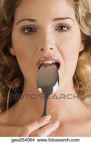 Portrait of a young woman with a spoon in her mouth View Large Photo Image Picture - Portrait of a young woman with a spoon in her mouth. Fotosearch