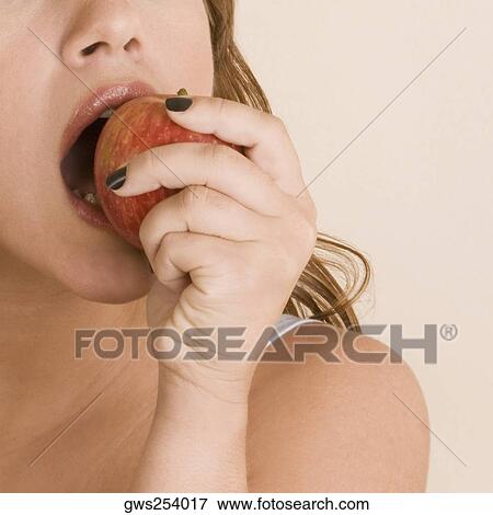 Young woman eating an apple View Large Photo Image Stock Photo - Young woman eating an apple. Fotosearch
