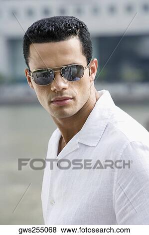 Close-up of a mid adult man wearing sunglasses View Large Photo Image Stock Photo - Close-up of a mid adult man wearing sunglasses. Fotosearch