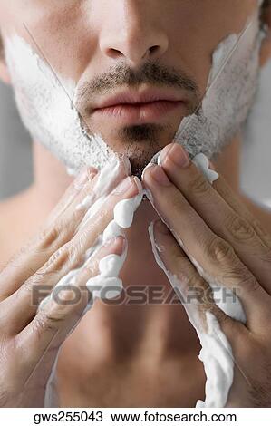 Close-up of a young man applying shaving cream on his face View Large Photo Image Stock Image - Close-up of a young man applying shaving cream on his face. Fotosearch