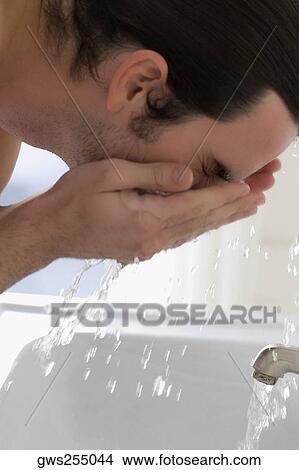 Close-up of a young man washing his face View Large Photo Image Picture - Close-up of a young man washing his face. Fotosearch
