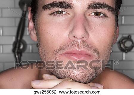 Close-up of a young man with his hands on his chin and thinking View Large Photo Image Stock Image - Close-up of a young man with his hands on his chin and thinking. Fotosearch