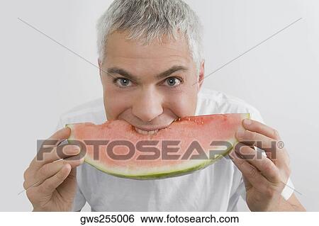 Portrait of a mature man eating a slice of watermelon View Large Photo Image Stock Photograph - Portrait of a mature man eating a slice of watermelon. Fotosearch