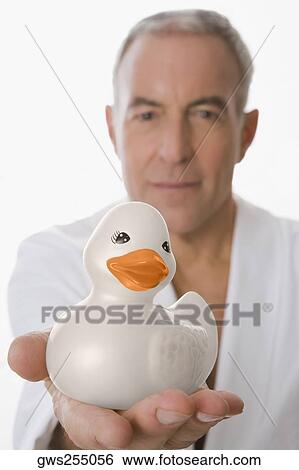 Portrait of a senior man holding a toy duck View Large Photo Image Stock Photograph - Portrait of a senior man holding a toy duck. Fotosearch