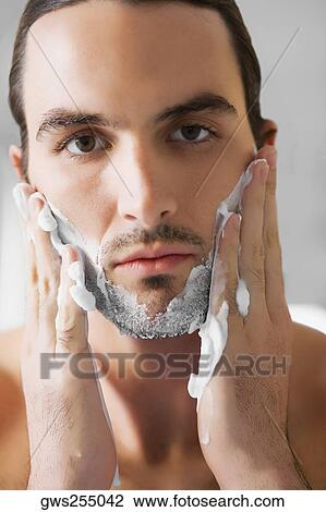 Portrait of a young man applying shaving cream on his face View Large Photo Image Stock Image - Portrait of a young man applying shaving cream on his face. Fotosearch