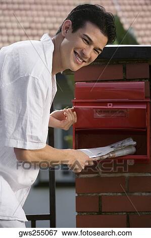 Portrait of a young man checking his mailbox and smiling View Large Photo Image Stock Photo - Portrait of a young man checking his mailbox and smiling. Fotosearch