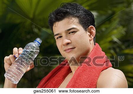 Portrait of a young man holding a water bottle View Large Photo Image Stock Image - Portrait of a young man holding a water bottle. Fotosearch