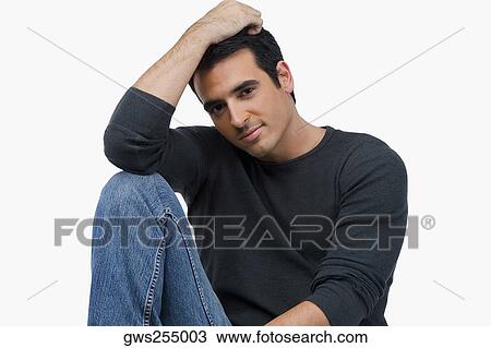 Portrait of a young man sitting with his hand in his hair View Large Photo Image Stock Image - Portrait of a young man sitting with his hand in his hair. Fotosearch