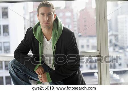 Portrait of a young man standing with his hand on his knee View Large Photo Image Stock Photo - Portrait of a young man standing with his hand on his knee. Fotosearch