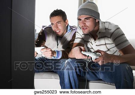 Two young men playing video game View Large Photo Image Stock Image - Two young men playing video game. Fotosearch