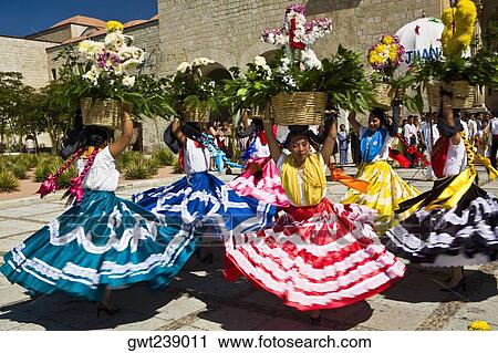 Stock Image - Female dancers dancing with potted plant over their head, Oaxaca, Oxaca State, Mexico. Fotosearch