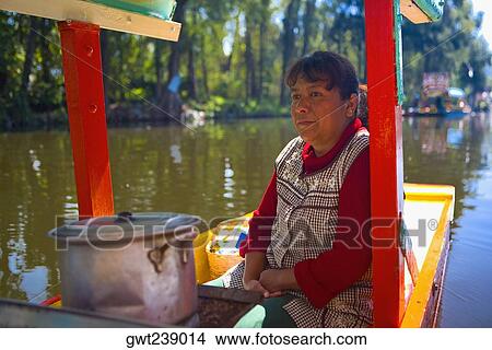 Picture - Mature woman traveling on a trajineras, Xochimilco, Mexico. Fotosearch