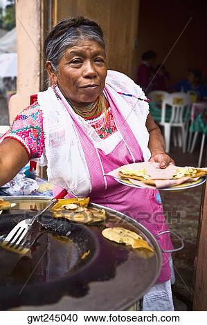 Stock Image - Portrait of a senior woman holding a plate of Mexican food, Cuetzalan, Puebla State, Mexico. Fotosearch