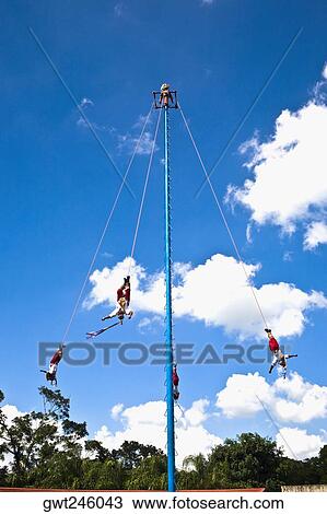 Stock Image - Low angle view of totonac voladores flying dancers flying from the pole, El Tajin, Veracruz, Mexico. Fotosearch