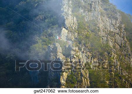 Low angle view of Mexican flag fluttering on a mountain, Waterfalls of the Monkeys, City Valleys, San Luis Potosi, Mexico View Large Photo Image Stock Image - Low angle view of Mexican flag fluttering on a mountain, Waterfalls of the Monkeys, City Valleys, San Luis Potosi, Mexico. Fotosearch