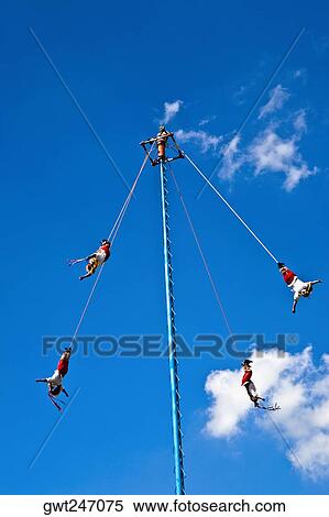Stock Photography - Low angle view of totonac voladores flying dancers flying from the pole, El Tajin, Veracruz, Mexico. Fotosearch