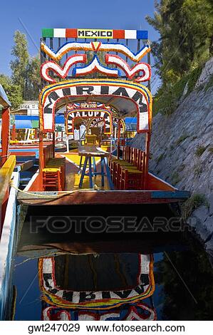 Reflection of a trajinerast boat in water, Xochimilco Gardens, Mexico City, Mexico View Large Photo Image Stock Photo - Reflection of a trajinerast boat in water, Xochimilco Gardens, Mexico City, Mexico. Fotosearch