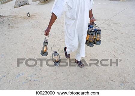 Stock Image - Egypt, Libyan desert, Siwa Oasis, Bedouin carrying lanterns. Fotosearch