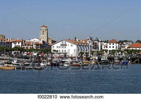 Stock Image - France, Aquitaine, Saint Jean de Luz, harbour and Saint John the Baptist Church. Fotosearch