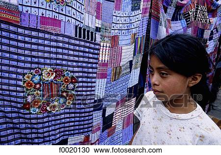 Stock Image - Guatemala, Santiago Atitlan, market, little girl and traditional embroidered shirt "huipil". Fotosearch