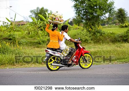 Indonesia, Bali, Sukawati, couple on a motorbike View Large Photo Image Stock Photo - Indonesia, Bali, Sukawati, couple on a motorbike. Fotosearch