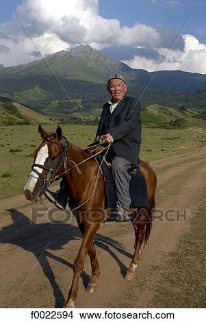 Picture - Kyrgyzstan, Kyrgyz man riding horse. Fotosearch