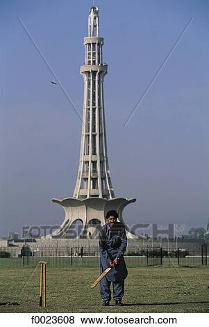 Stock Photo - Pakistan, Punjab, Lahore, Minar-e-Pakistan and man playing cricket. Fotosearch