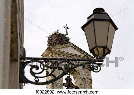 Stock Image - Portugal, Algarve, Faro, streetlight and stork nest. Fotosearch