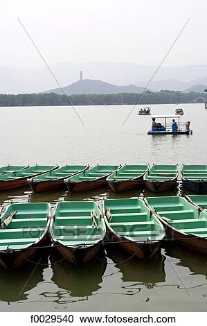 Stock Image - China, Beijing, Summer Palace "Yiheyuan", boats on the Kunming Lake and Yu Quan Hill in the background. Fotosearch