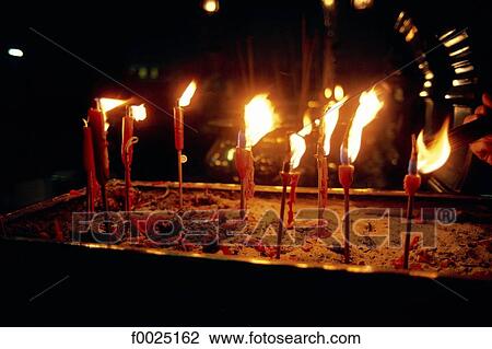 Stock Image - China, Foshan, Taoist temple, votive candles. Fotosearch
