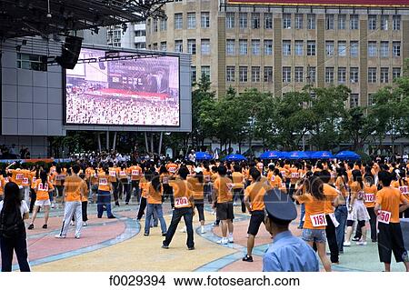 China, Shanghai, Nanjing pedestrian street, practicing gymastics in a group by a giant screen View Large Photo Image Picture - China, Shanghai, Nanjing pedestrian street, practicing gymastics in a group by a giant screen. Fotosearch