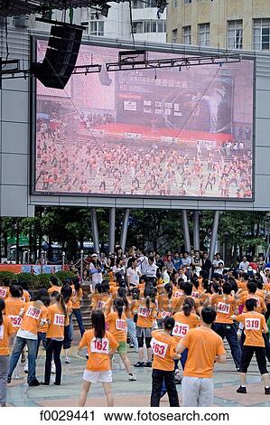 China, Shanghai, Nanjing pedestrian street, practicing gymastics in a group by a giant screen View Large Photo Image Stock Image - China, Shanghai, Nanjing pedestrian street, practicing gymastics in a group by a giant screen. Fotosearch