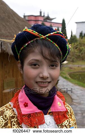China, Yunnan, near Kunming, Yunnan Nationalities Village, young woman wearing traditional costume View Large Photo Image Stock Photo - China, Yunnan, near Kunming, Yunnan Nationalities Village, young woman wearing traditional costume. Fotosearch