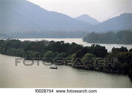 Picture - China, Zhejiang, Hangzhou, overview on the great lake and forest. Fotosearch