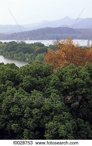 Stock Image - China, Zhejiang, Hangzhou, overview on the great lake and forest. Fotosearch