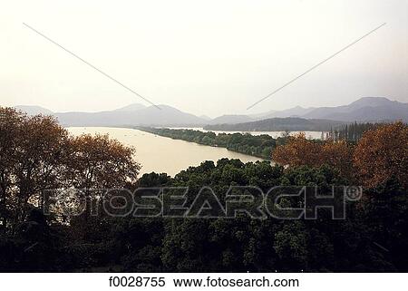 Stock Photography - China, Zhejiang, Hangzhou, overview on the great lake and forest. Fotosearch